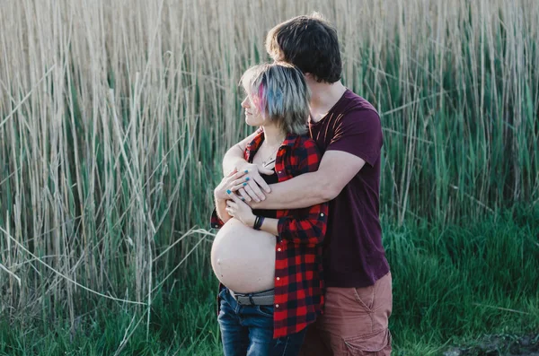 Väntar på barn. Glad och ung gravid par kramar i NAT — Stockfoto