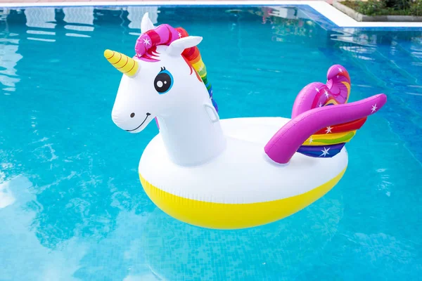 Unicorn pool float in blue water background, inflatable swim tub