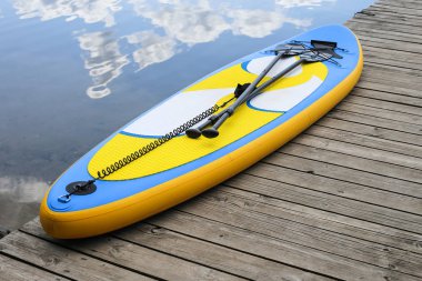 Nehir yakınında şişme Sup kurulu kapatın. Sup board, ayağa kalk
