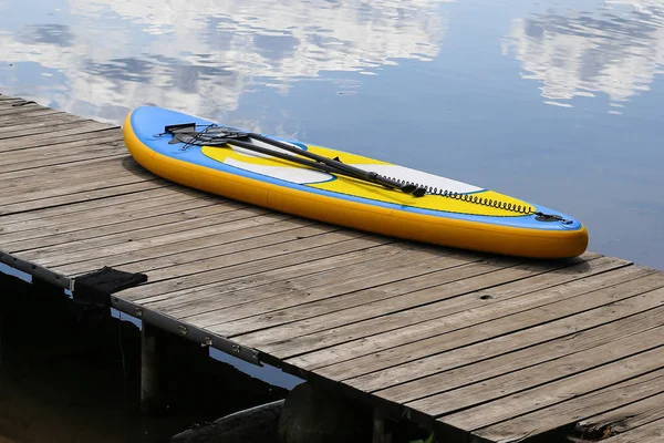 Deska SUP, stand up paddleboard w pobliżu rzeki na molo — Zdjęcie stockowe