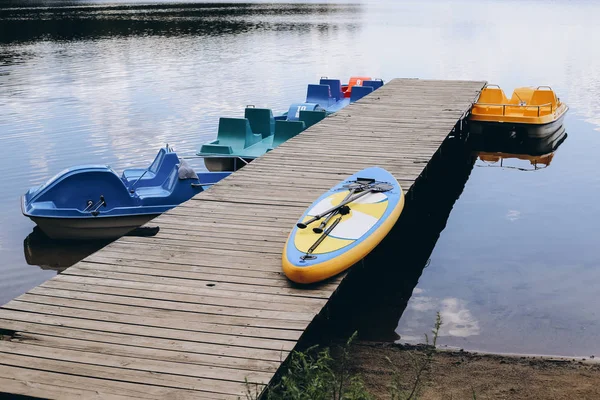 Levez-vous planche à pagaie avec des vélos d'eau près de la rivière. Panneau de soutien , — Photo