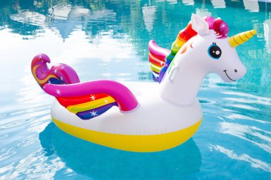 Unicorn pool float in blue water background. Unicorn inflatable  clipart