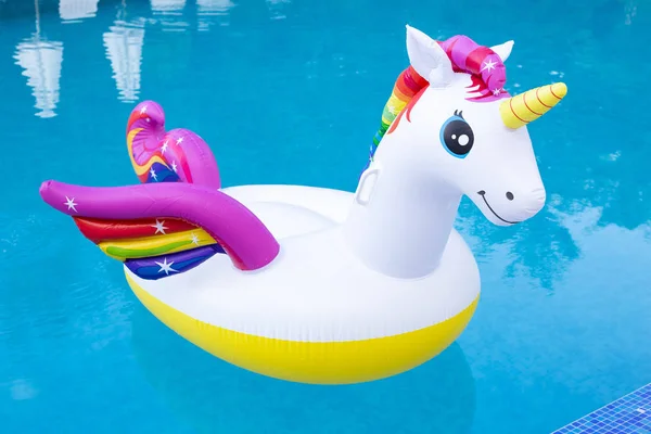 Unicornio inflable de color arco iris flotando en una piscina — Foto de Stock