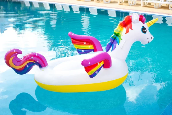 Unicorn floating in swimming pool. Unicorn inflatable pool float