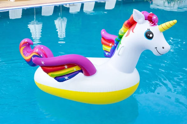 Unicorn pool float in blue water background, inflatable swim tub