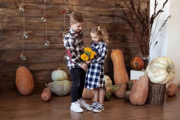 秋に黄色い花の花束を持つ少年と少女。愛のコンク — ストック写真