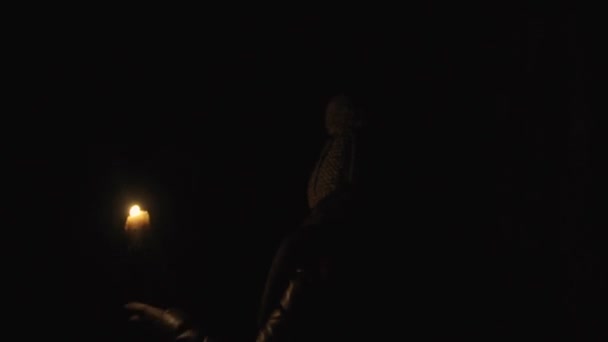 Horror - meisje met een kaars in een donkere kelder — Stockvideo