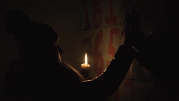 Horror - girl with a candle in a dark basement — Stock Video