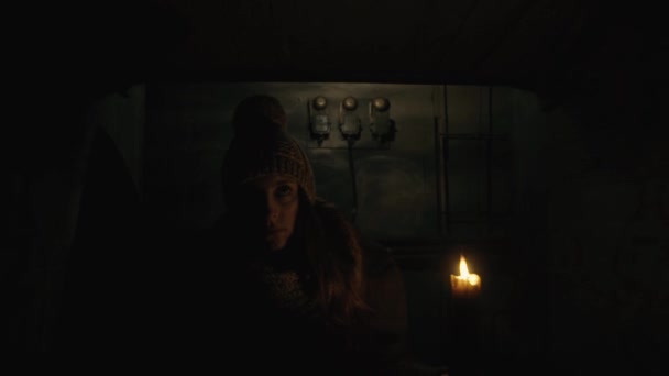 Ужас - девушка со свечкой в темном подвале — стоковое видео