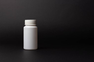 siyah arka plan üzerine bir beyaz hap şişe. depolama hapları. vitaminler. Yayın hapları.