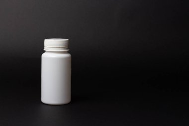siyah arka plan üzerine bir beyaz hap şişe. depolama hapları. vitaminler. Yayın hapları.