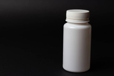 siyah arka plan üzerine bir beyaz hap şişe. depolama hapları. vitaminler. Yayın hapları.