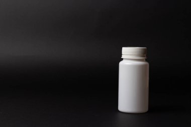 siyah arka plan üzerine bir beyaz hap şişe. depolama hapları. vitaminler. Yayın hapları.