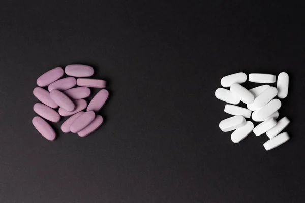 Dvě Hromádky Pilulek Leží Černém Pozadí Bílá Fialová Volba Závislost — Stock fotografie