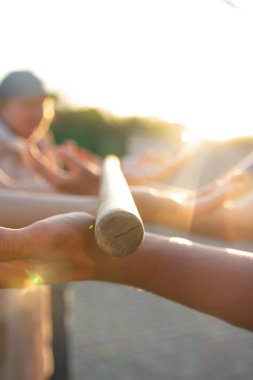 Bulanık eller bir bulanık, ahşap sopa tutun. bir sopa ve elleri ile ekip oluşturma etkinliği. toplu destek ve yardım. iş arkadaşları. Güneş sonbahar, ellerinizi ve sopa, ışık ışınlarının yol göstermek