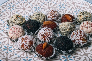 tatlılar Kuruyemiş ile fındık ve susam tohumu kurutulmuş meyve ve fındık Hindistan cevizi fiş beyaz tabakta ile lezzetli enerji topları