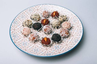 tatlılar Kuruyemiş ile fındık ve susam tohumu kurutulmuş meyve ve fındık Hindistan cevizi fiş beyaz tabakta ile lezzetli enerji topları