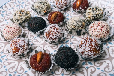 tatlılar Kuruyemiş ile fındık ve susam tohumu kurutulmuş meyve ve fındık Hindistan cevizi fiş beyaz tabakta ile lezzetli enerji topları