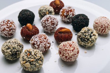 tatlılar Kuruyemiş ile fındık ve susam tohumu kurutulmuş meyve ve fındık Hindistan cevizi fiş beyaz tabakta ile lezzetli enerji topları