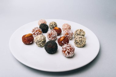 tatlılar Kuruyemiş ile fındık ve susam tohumu kurutulmuş meyve ve fındık Hindistan cevizi fiş beyaz tabakta ile lezzetli enerji topları