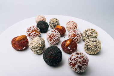 tatlılar Kuruyemiş ile fındık ve susam tohumu kurutulmuş meyve ve fındık Hindistan cevizi fiş beyaz tabakta ile lezzetli enerji topları