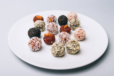 tatlılar Kuruyemiş ile fındık ve susam tohumu kurutulmuş meyve ve fındık Hindistan cevizi fiş beyaz tabakta ile lezzetli enerji topları