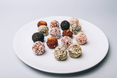 tatlılar Kuruyemiş ile fındık ve susam tohumu kurutulmuş meyve ve fındık Hindistan cevizi fiş beyaz tabakta ile lezzetli enerji topları