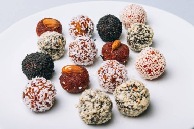 tatlılar Kuruyemiş ile fındık ve susam tohumu kurutulmuş meyve ve fındık Hindistan cevizi fiş beyaz tabakta ile lezzetli enerji topları