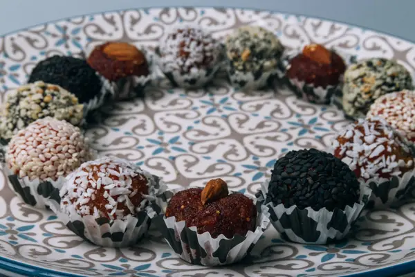 tatlılar Kuruyemiş ile fındık ve susam tohumu kurutulmuş meyve ve fındık Hindistan cevizi fiş beyaz tabakta ile lezzetli enerji topları