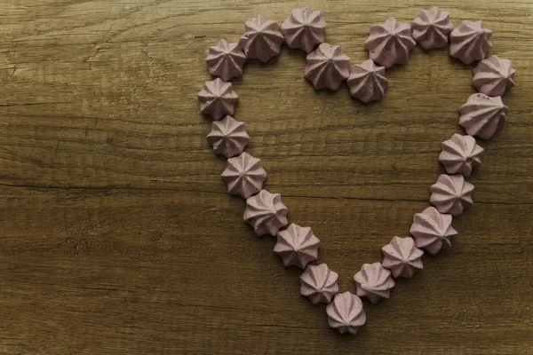 purple heart made of marshmallows on a wooden table.day of St. Valentine