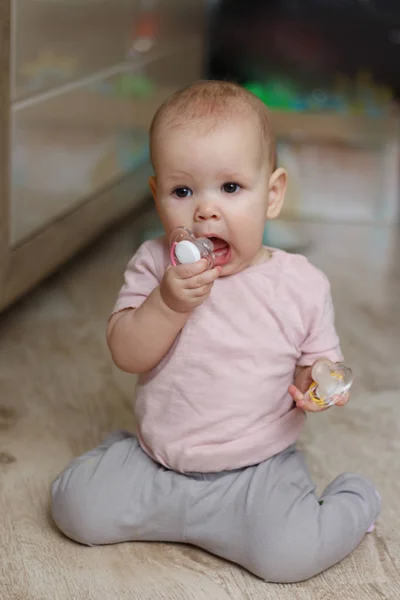 Маленькая Девочка Успокаивающим Малыш Соской Розовом Свитере Серых Брюках Сидит — стоковое фото