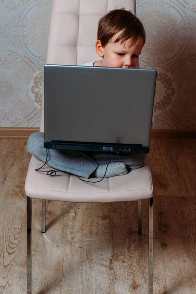 Chlapeček Bílé Tričko Sedí Židli Pohovka Přenosným Počítačem Pohledy Kamery — Stock fotografie