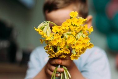 bulanıklık. Çocuk sarı alan çiçek tutuyor. Onlara - kamerada gösterilen verir. Annem için bir hediye. bir buket vermek. hediye - bulanık buket çiçek. yaz