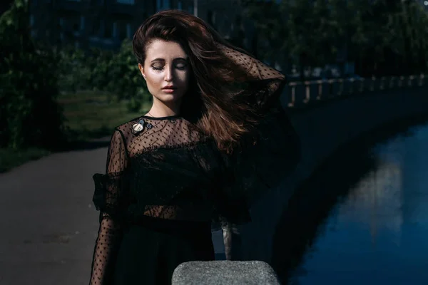 Retrato de una hermosa chica en la calle en el puente cerca del río — Foto de Stock