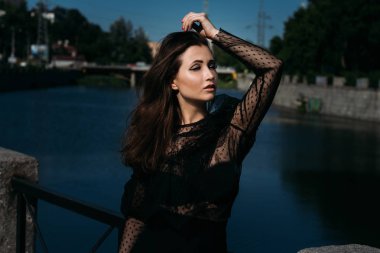 sokaktaki bir güzel kız portresi. esmer siyah giysili şehrin Nehri yakınında köprüde üzgün olanıdır. cinsellik