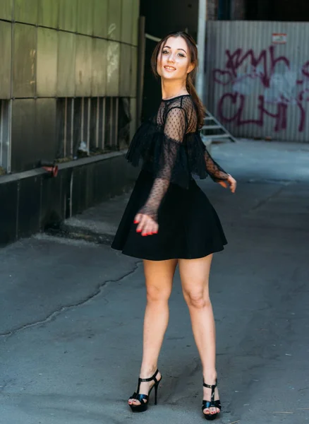 Emotional portrait of Fashion stylish portrait of pretty young woman. city portrait. sad girl. brunette in a black dress with stars and planets on a dress. expectation. dreams. beautiful brunette whirls around in the city. happy and cheerful. black d