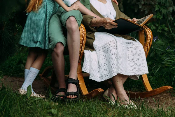 Avó Com Seus Netos Sentados Uma Cadeira Balanço Jardim Assistindo — Fotografia de Stock