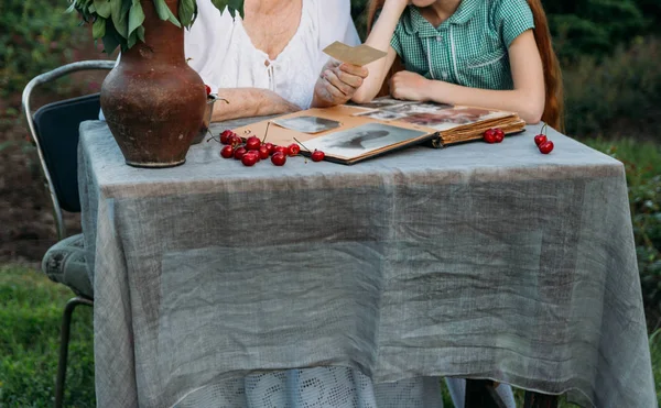 Mormor Sitter Vid Bordet Med Dotterdottern Visar Henne Ett Gamla — Stockfoto