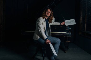 adamın yanında siyah bir piyano notlar görünüyor