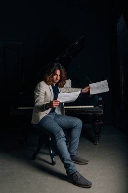 adamın yanında siyah bir piyano notlar görünüyor