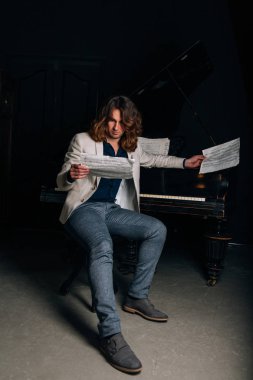 adamın yanında siyah bir piyano notlar görünüyor