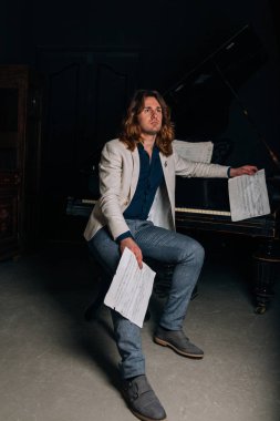 adamın yanında siyah bir piyano notlar görünüyor