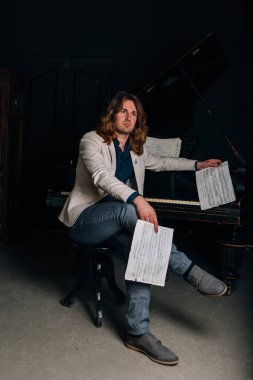 adamın yanında siyah bir piyano notlar görünüyor