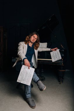 adamın yanında siyah bir piyano notlar görünüyor