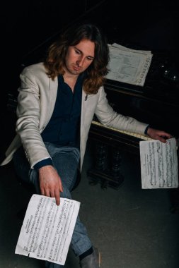 adamın yanında siyah bir piyano notlar görünüyor