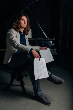 adamın yanında siyah bir piyano notlar görünüyor