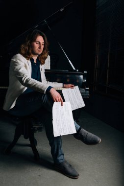 adamın yanında siyah bir piyano notlar görünüyor