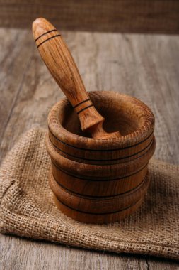 ahşap stupa ve havaneli çuval bezi köyü tablo üzerinde. Mutfak eşyaları. ezmek. Dikey metin için bir boşluk ile ateş. Menü, baharatlar. el ile baharat ıslah çevre dostu malzeme. ekoloji. doğallığı