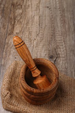 ahşap stupa ve havaneli çuval bezi köyü tablo üzerinde. Mutfak eşyaları. ezmek. Dikey metin için bir boşluk ile ateş. Menü, baharatlar. el ile baharat ıslah çevre dostu malzeme. ekoloji. doğallığı