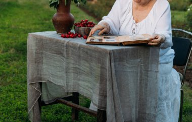 Yaşlı anıları. Büyükanne ziyaret edin. bahçede bir sandalyede oturan ve fotoğraflar, eski bir albüm izlerken Büyükanne anlatıyor ve familys hikaye hatırlar.